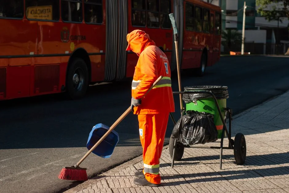 Side view of young ethnic male in uniform cleaning floor with mop while working in retro styled restaurant